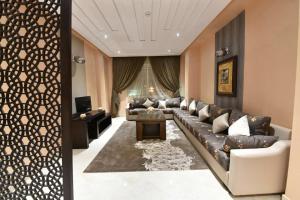 uma sala de estar com um sofá e uma mesa em Bellington Appart Hôtel em Saidia 