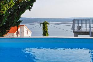 een blauw zwembad met uitzicht op het water bij Holiday Home Marija with Pool & Garden & Amazing Sea View in Dramalj