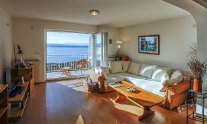 a living room with a couch and a view of the ocean at Holiday Home Marija with Pool & Garden & Amazing Sea View in Dramalj