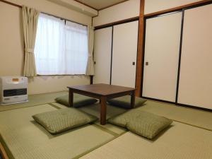 een kamer met een tafel en een aantal ramen en een tafel bij サムライ シティ イン 信夫屋 in Aizuwakamatsu