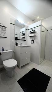 een witte badkamer met toilet en douche bij La Duchesse, Studio cosy à Versailles, à 2 min du Château in Versailles +29 foto's