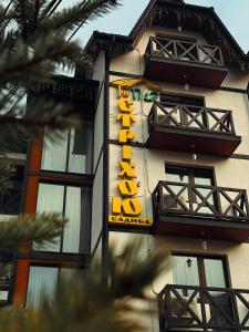 une enseigne d'hôtel sur le côté d'un bâtiment dans l'établissement Hotel Pid Strihoju, à Bukovel