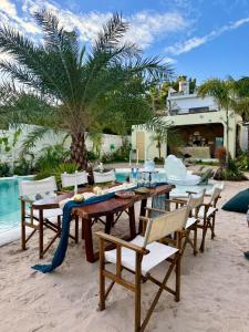 un tavolo e sedie su una spiaggia con una palma di Chon's Dock Homestay & Apartment For Lease a Phan Thiet