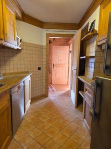 a kitchen with a door leading into a kitchen with a refrigerator at Meleres 11 in Cortina dʼAmpezzo +19 photos