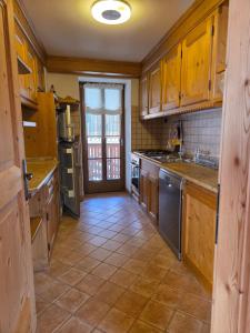 a kitchen with wooden cabinets and stainless steel appliances at Meleres 11 in Cortina dʼAmpezzo