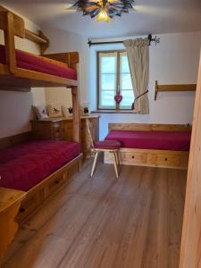 a bedroom with two bunk beds and a window at Meleres 11 in Cortina dʼAmpezzo