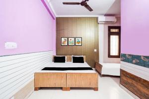 een slaapkamer met een bed in een kamer bij Hotel O Pushpanjali in Haldwani