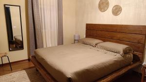 a bed in a bedroom with a wooden headboard at Pangea - Africa in Trani