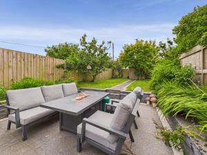 een patio met een tafel en 2 stoelen bij Cosy Cornish Cottage with Firepit & Parking in Newlyn East