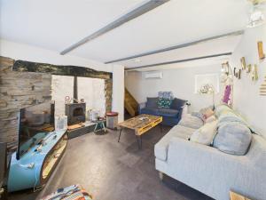 een man op een bank in een woonkamer bij Cosy Cornish Cottage with Firepit & Parking in Newlyn East +30 foto's