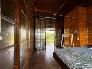 a bedroom with a bed and a wooden wall at The Rustic Tree Farm in Thôn An Thạnh