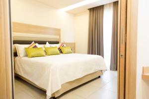 1 dormitorio con 1 cama grande con almohadas amarillas en Hotel Agora Sure Hotel Collection by Best Western, en Lago Patria