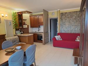 a kitchen and a living room with a red couch at Vista Garda, Casa Vacanze in Roe