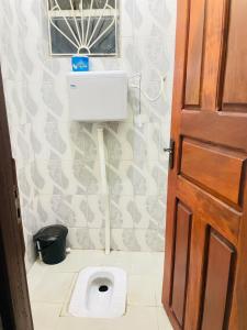 a bathroom with a toilet and a window and a door at KidotuiVillaHome in Arusha +44 photos