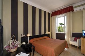 a hotel room with a bed and a dresser at Hotel Le Focette in Marina di Pietrasanta