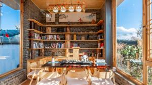 een kamer met een tafel en stoelen en boekenplanken bij Nostalgia 28 lodge in Baisha