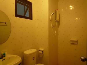 une salle de bains avec toilettes, lavabo et miroir dans l'établissement Erawan Place, à Mae Sot