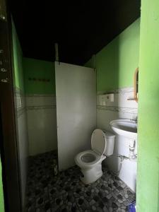 a bathroom with a toilet and a sink at The Rustic Tree Farm in Thôn An Thạnh