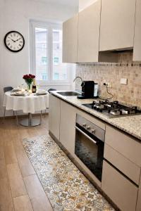 een keuken met een fornuis top oven naast een tafel bij Lucens Domus Appartamento Roma quartiere Trieste - vicino Metro b1 - in Rome