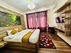 een slaapkamer met een bed en een bureau erin bij Prem Durbar Hotel in Changunarayan