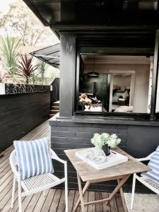 a patio with a table and two chairs and a bedroom at Courtyard Pool Studio Private Luxe Retreat in Coal Point