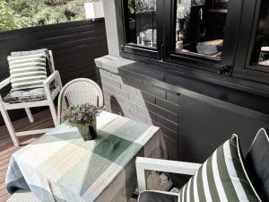 a table and chairs on a porch with a table and flowers at Pool Heated Lake Views 1BR Apartment in Coal Point