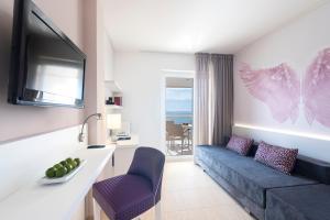 a living room filled with furniture and a tv at Aparthotel Tropic Garden in Santa Eularia des Riu
