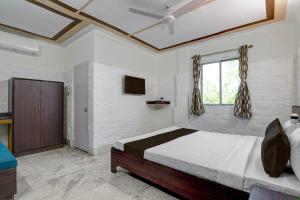ein Schlafzimmer mit einem großen Bett und einem Fenster in der Unterkunft Hotel O Galaxy Inn in Ballygunge + 36 Fotos