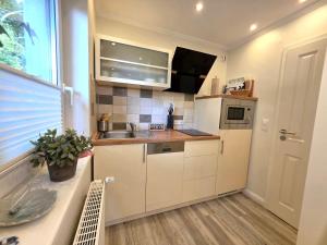 a small kitchen with a sink and a refrigerator at Ferienwohnung Smutje in Kiel