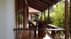 una veranda di una casa con tavolo e sedia di River Park Resort a Yan Ta Khao