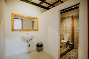 een badkamer met een wastafel en een spiegel aan de muur bij Nuansa Penida Hostel in Nusa Penida +46 foto's