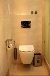 ein Badezimmer mit einem weißen WC und einem Mülleimer in der Unterkunft Dastan Grand Hotel in Jalal-Abad + 39 Fotos