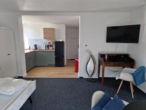 a living room with a couch and a kitchen at Modernes Apartment in Huttenberg
