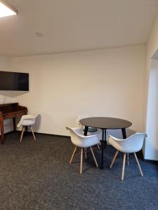 a conference room with a table and chairs and a piano at Modernes Apartment in Huttenberg +2 photos