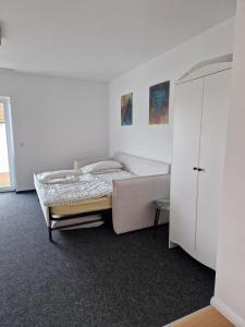 a bedroom with a bed and a white cabinet at Modernes Apartment in Huttenberg