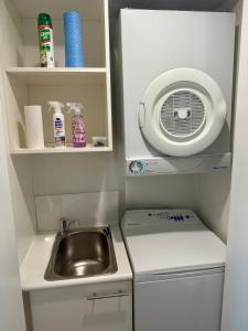 une petite cuisine avec un évier et un micro-ondes dans l'établissement HAVEN by the Sea, à Mandurah