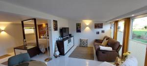 a living room with a couch and a mirror at Gartencharlet in Extertal