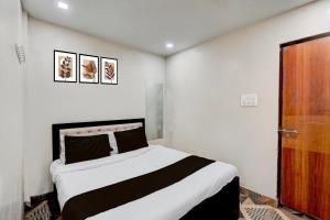 una camera con un grande letto e una porta in legno di HOTEL O METRO STAY a Itwāri Altre 58 foto