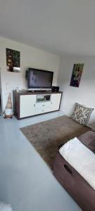 a bedroom with a flat screen tv on the wall at Gartencharlet in Extertal +10 photos