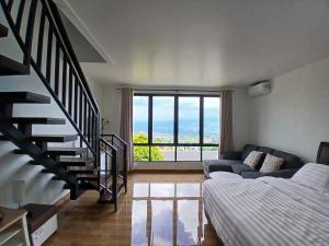a living room with a staircase and a bed at Anemos Resort By Tamastu in Pasirpogor +42 photos