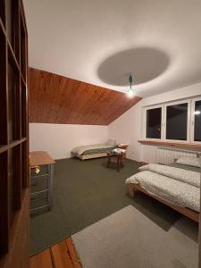 a bedroom with two beds and a wooden ceiling at CityHalo Hostel in Marki