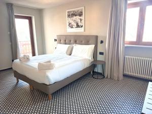 een slaapkamer met een groot bed met witte lakens bij Central Guest in Sauze dʼOulx