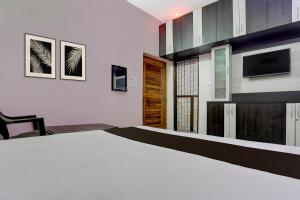 een slaapkamer met een groot bed en een tv bij Hotel O shreyansh in Chupra