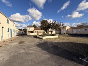 an empty parking lot with a tree in the middle at Les Sables in Saint-Georges-dʼOléron
