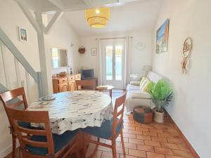 a living room with a table and a couch at Les Sables in Saint-Georges-dʼOléron