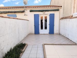 a house with a blue door and a patio at Les Sables in Saint-Georges-dʼOléron +7 photos