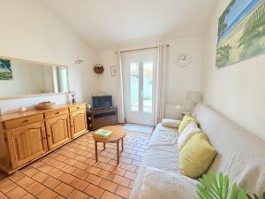 a living room with a couch and a table at Les Sables in Saint-Georges-dʼOléron
