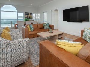 un soggiorno con divani e TV a schermo piatto di Absolute Ocean Boutique Guesthouse a Hermanus