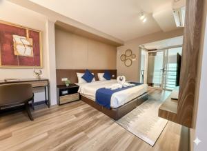 ein Hotelzimmer mit einem Bett, einem Schreibtisch und einem Tisch in der Unterkunft Romatic Seaview Maritime Suite near Jelutong by Golden Hour 0706 in George Town + 39 Fotos