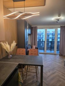 una sala da pranzo con tavolo e sedie e un soggiorno di Green Baltic Portovo Comfort Apartment City Center Balcony a Danzica